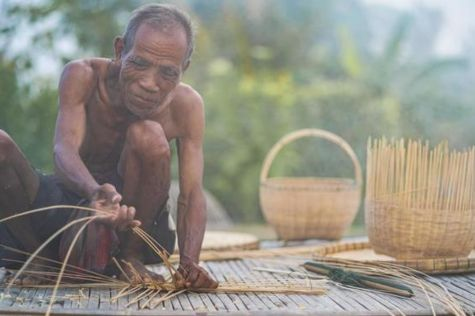 An old man is making bamboo handicraft