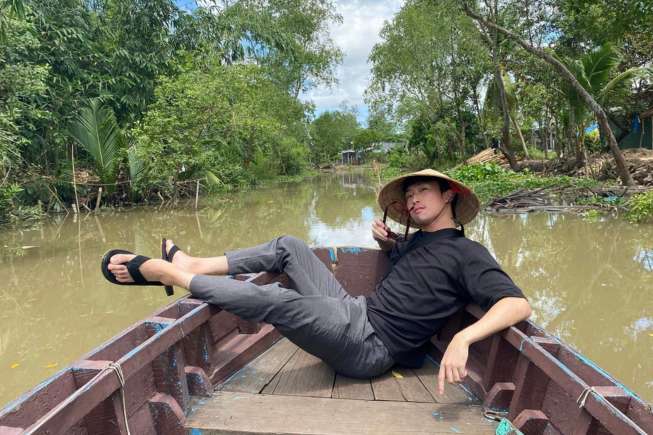 Tourists sit on a boat to visit the Mekong Delta.