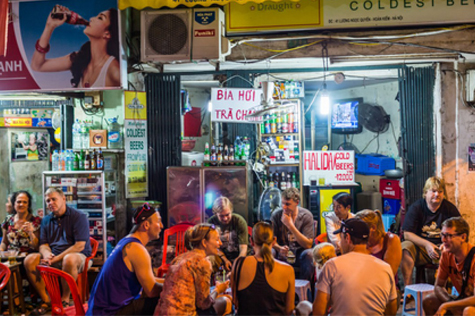 Tourists eat and drink at Hanoi street restaurants.