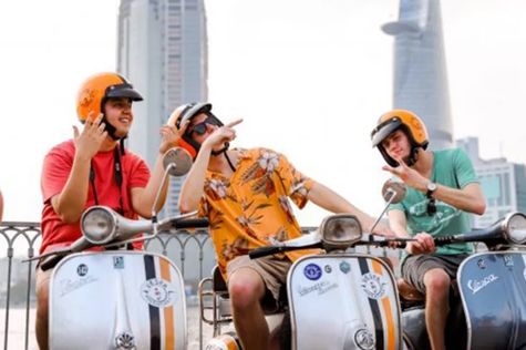 Tourists driving vespa in Ho Chi Minh City